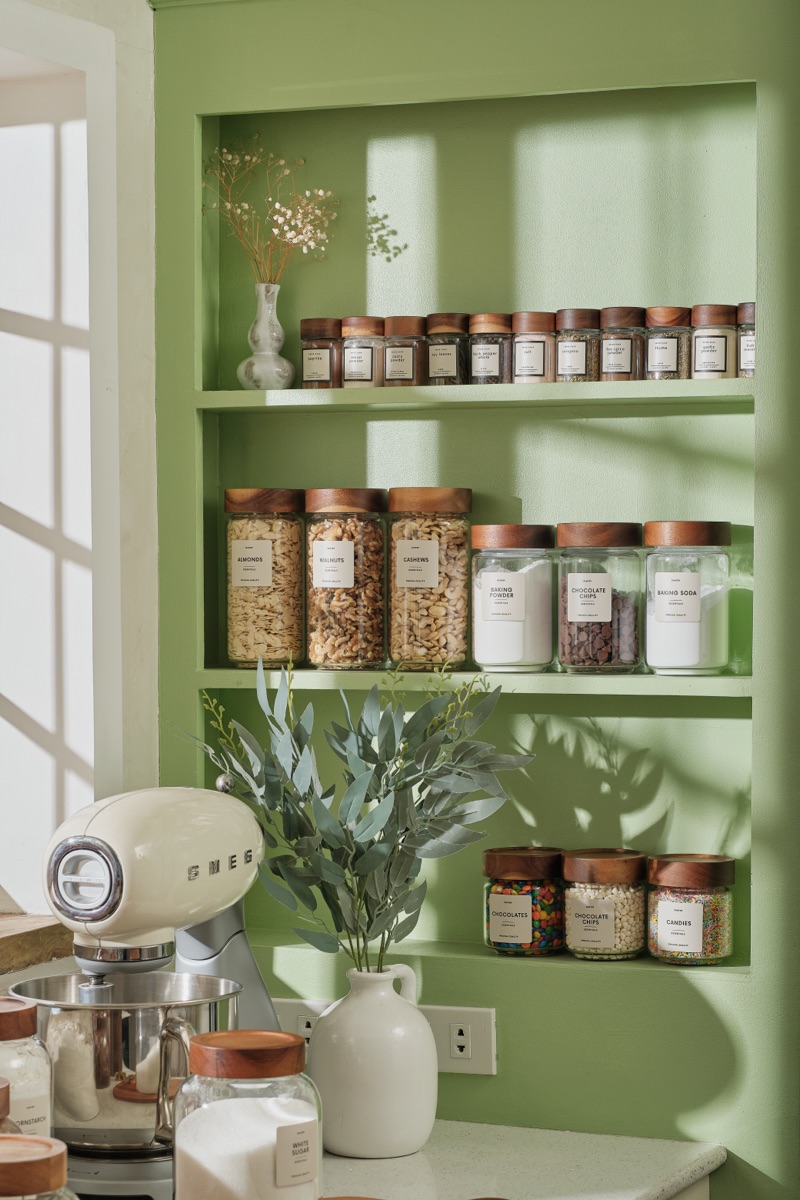 A green pantry niche with labeled jars, styled by Mayfair & Co.